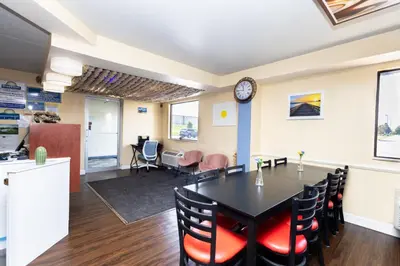 a dining room with a table and chairs and a clock at Days Inn by Wyndham Dayton Huber Heights Northeast in Huber Heights