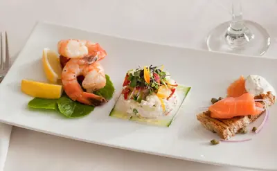a white plate of food with shrimp and vegetables at The Inn at Honey Run Millersburg in Millersburg