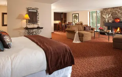 a hotel room with a bed and a living room at The Inn at Honey Run Millersburg in Millersburg