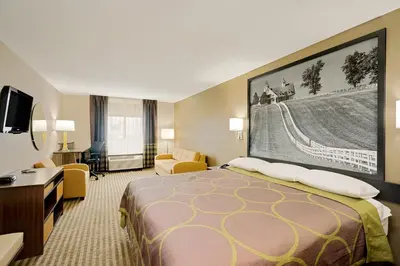 a hotel room with a large bed and a desk at Super 8 by Wyndham Lexington Hamburg Area in Lexington