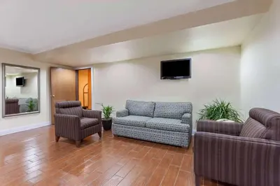 a living room with a couch and two chairs at Super 8 by Wyndham Lexington Hamburg Area in Lexington