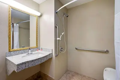 a bathroom with a sink and a mirror at Super 8 by Wyndham Lexington Hamburg Area in Lexington
