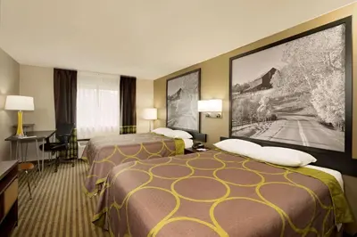 a hotel room with two beds and a desk at Super 8 by Wyndham Lexington Hamburg Area in Lexington
