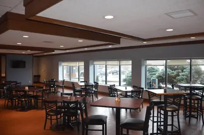 a dining room with tables and chairs and windows at Quality Inn Perrysburg - Toledo South in Perrysburg