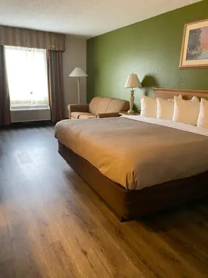 a hotel room with a large bed and a couch at Quality Inn Perrysburg - Toledo South in Perrysburg