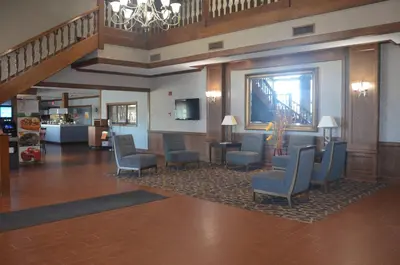 a lobby with chairs and tables and a staircase at Quality Inn Perrysburg - Toledo South in Perrysburg