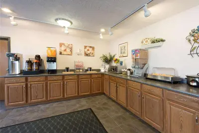 a kitchen with wooden cabinets and a counter top at Super 8 by Wyndham Greenfield in Greenfield