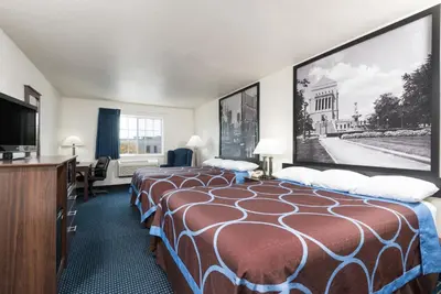 a hotel room with two beds and a flat screen tv at Super 8 by Wyndham Greenfield in Greenfield