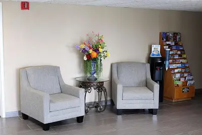 two chairs and a vase of flowers on a table at Baymont by Wyndham Springfield in Springfield