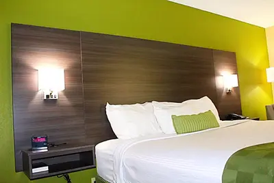 a bedroom with a large bed with a large headboard at Baymont by Wyndham Springfield in Springfield