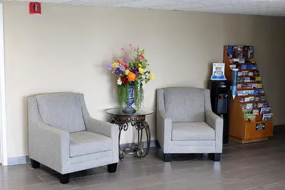 two chairs and a vase of flowers on a table at Baymont by Wyndham Springfield in Springfield