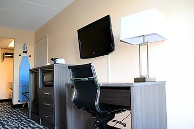 a room with a desk with a television and a chair at Baymont by Wyndham Springfield in Springfield