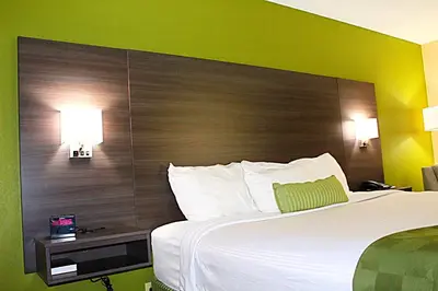 a bedroom with a large bed with a large headboard at Baymont by Wyndham Springfield in Springfield