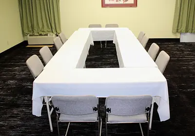 a long white table in a room with chairs at Baymont by Wyndham Springfield in Springfield