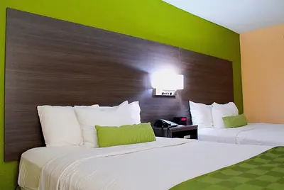 a hotel room with two beds and a green wall at Baymont by Wyndham Springfield in Springfield
