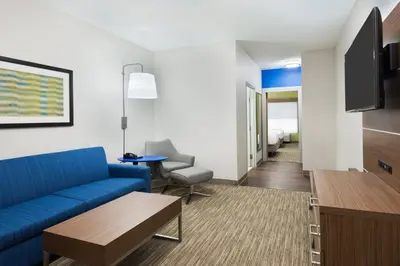 a living room with a blue couch and a table at Holiday Inn Express & Suites - Columbus Airport East by IHG in Columbus