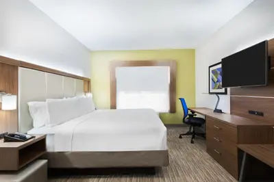 a hotel room with a bed and a desk and a tv at Holiday Inn Express & Suites - Columbus Airport East by IHG in Columbus
