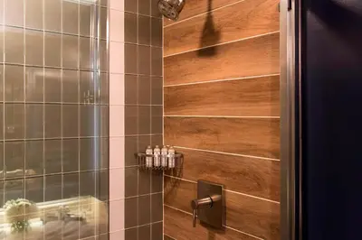 a bathroom with a shower with a wooden wall at Renaissance Toledo Downtown Hotel in Toledo