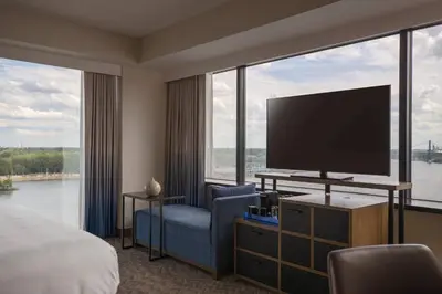 a hotel room with a bed and a tv and large windows at Renaissance Toledo Downtown Hotel in Toledo