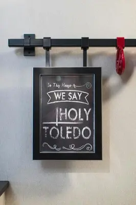 a sign that says we say holy toledo on a wall at Renaissance Toledo Downtown Hotel in Toledo