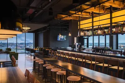 a bar with chairs and tables and windows at Renaissance Toledo Downtown Hotel in Toledo