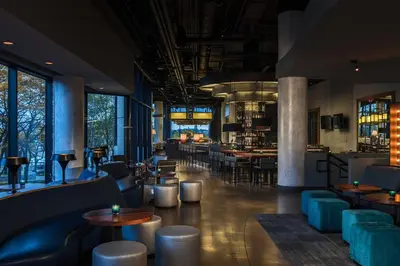 a restaurant with tables and chairs and a bar at Renaissance Toledo Downtown Hotel in Toledo
