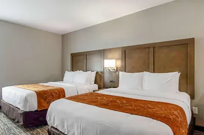 two beds in a hotel room with white pillows at Comfort Suites Grove City - Columbus South in Grove City