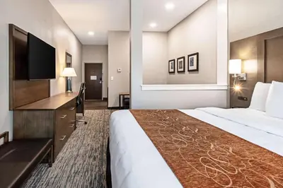 a hotel room with a large bed and a flat screen tv at Comfort Suites Grove City - Columbus South in Grove City