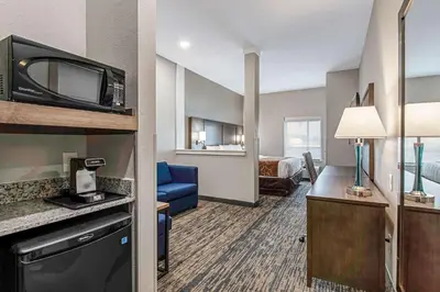 a hotel room with a bed and a living room at Comfort Suites Grove City - Columbus South in Grove City