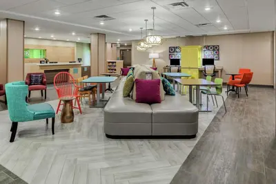 a lobby with a couch and tables and chairs at Home2 Suites By Hilton Dayton Centerville in Centerville