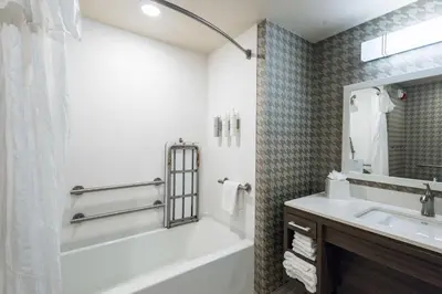 a bathroom with a white tub and a sink at Home2 Suites By Hilton Dayton Centerville in Centerville