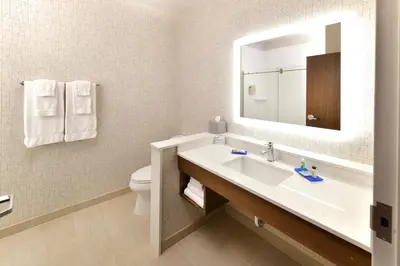 a bathroom with a sink and a toilet and a mirror at Holiday Inn Express & Suites - Millersburg by IHG in Millersburg