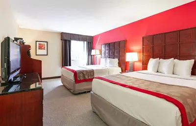 a hotel room with two beds and a flat screen tv at Ramada by Wyndham Columbus North in Westerville