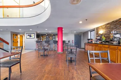 a restaurant with tables and chairs and a red pole at Ramada by Wyndham Columbus North in Westerville