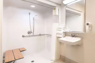 a white bathroom with a sink and a mirror at Baymont by Wyndham Columbus/Rickenbacker in Columbus