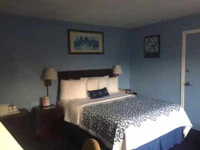 a bedroom with a bed and a blue wall at Days Inn by Wyndham Cleveland Lakewood in Lakewood