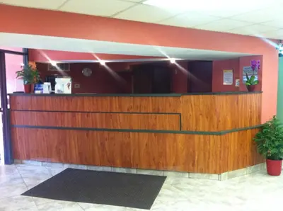 a lobby with a wooden counter in a building at Days Inn by Wyndham Cleveland Lakewood in Lakewood