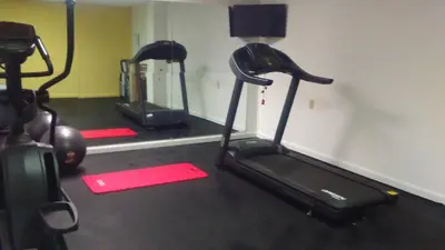 a gym with two exercise bikes and a treadmill at Days Inn by Wyndham Cleveland Lakewood in Lakewood