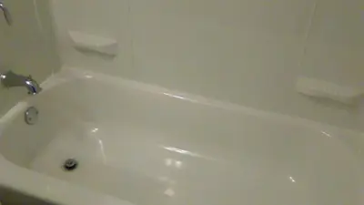 a white bath tub with a faucet in a bathroom at Days Inn by Wyndham Cleveland Lakewood in Lakewood