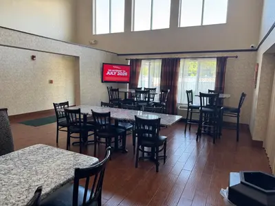 a restaurant with tables and chairs and a television at Quality Inn & Suites Middletown - Franklin in Franklin