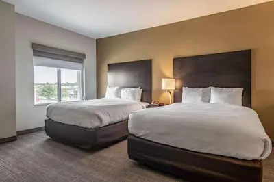 a hotel room with two beds and a window at Comfort Suites Brunswick Town Center in Brunswick