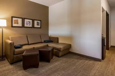 a living room with a couch and stool in a room at Comfort Suites Brunswick Town Center in Brunswick