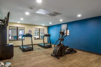 a gym with three exercise bikes and a blue wall at Comfort Suites Brunswick Town Center in Brunswick