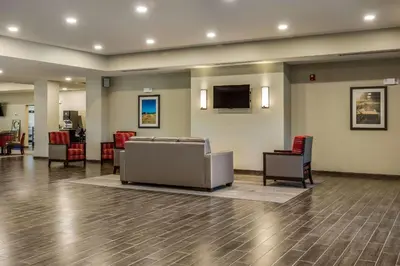 a waiting room with chairs and a couch and a tv at Comfort Suites Brunswick Town Center in Brunswick