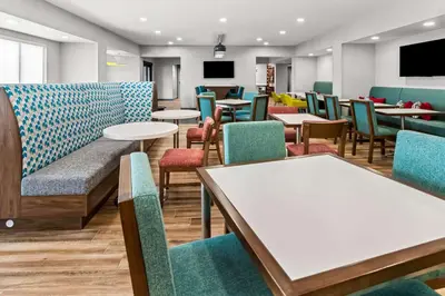 a waiting room with tables and chairs at Hampton Inn by Hilton Dayton South in Miamisburg