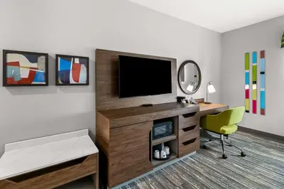 a living room with a tv and a chair at Hampton Inn by Hilton Dayton South in Miamisburg