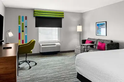 a hotel room with a bed and a desk and chair at Hampton Inn by Hilton Dayton South in Miamisburg