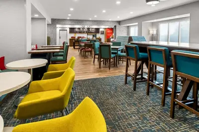 a restaurant with tables and chairs and a bar at Hampton Inn by Hilton Dayton South in Miamisburg