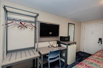 a hotel room with a desk and a bed at Budget Inn Columbus in Lockbourne