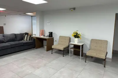 a waiting room with a couch and two chairs at Suburban Studios Fairborn - Dayton in Fairborn